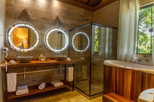 a bathroom with two sinks and a tub and mirrors at Don Pascual in Rio de Janeiro