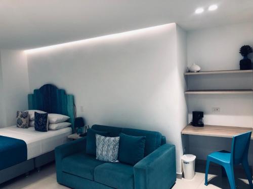 a bedroom with a blue couch and a bed at White Coral ApartaSuites in San Andrés