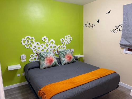 1 dormitorio con 1 cama grande y paredes verdes en Vv La Joya Del Mar Suites en Garachico