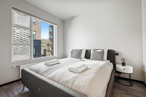 1 dormitorio con 1 cama grande y ventana grande en Cozy Lux 2BR & 2BA City Center with Free Parking en Reikiavik