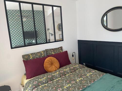 1 dormitorio con cama y espejo en la pared en Le Saint-André, Gare de Rouen, en Rouen