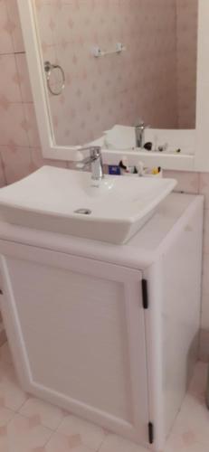 La salle de bains est pourvue d'un lavabo blanc et d'un miroir. dans l'établissement Villa Bella Quatre Cocos, à Trou dʼ Eau Douce