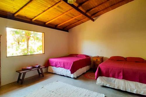 a bedroom with two beds and a window at Casa de Miroca in Uruçuca