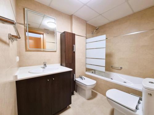 a bathroom with a sink and a toilet and a mirror at Apartamento Miró in Calpe