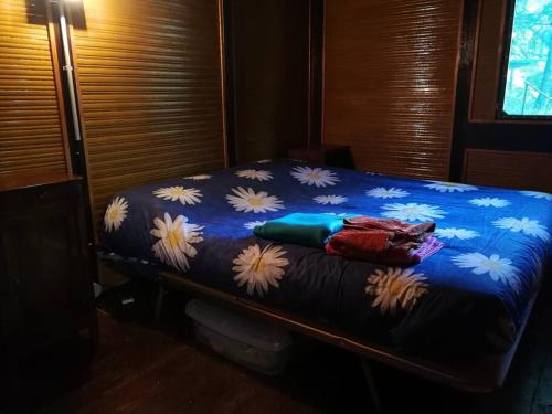 Una cama con una manta azul con flores blancas. en Casa d' Amore, 
