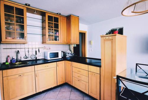 a kitchen with wooden cabinets and black counter tops at Ferienwohnung in Hornstein in Bingen