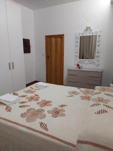 a bedroom with a large bed and a mirror at Casavacanze Vicolo Mentana in Foligno