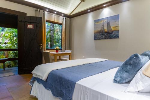 a bedroom with a bed and a table and a window at Don Pascual in Rio de Janeiro