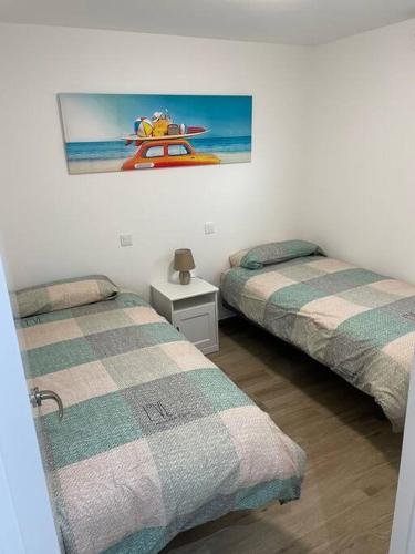 a bedroom with two beds and a picture of a boat at Apartment Montaña Clara & pool in Mogán