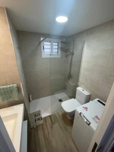 a bathroom with a toilet and a glass shower at Apartment Montaña Clara & pool in Mogán