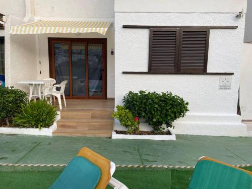 two chairs and a table in front of a house at Apartment Montaña Clara & pool in Mogán