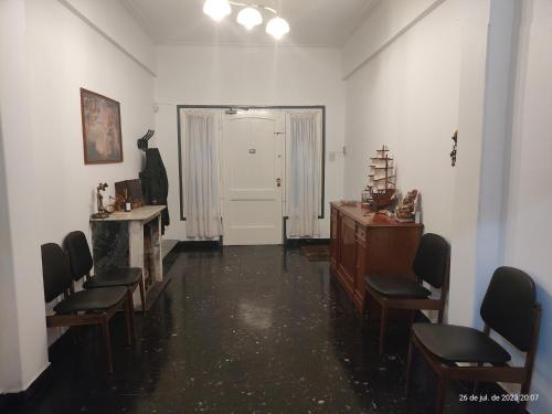 - une salle d'attente avec des chaises, une table et une porte blanche dans l'établissement Buenos Aires, CABA, à Buenos Aires
