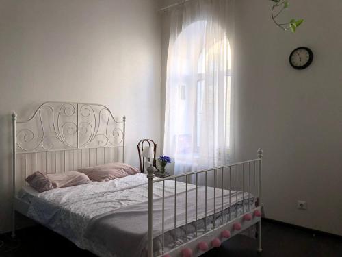 um quarto com uma cama e uma janela com um relógio em Makij apartment for night 4 em Narva