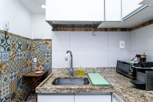 uma cozinha com um lavatório e uma bancada em Garden Rio - Facilidade e Tranquilidade! no Rio de Janeiro