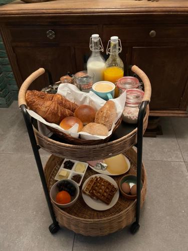 un panier de pain et d'autres aliments sur une table dans l'établissement B&B de wetenschap (der gastvrijheid), à Kruisland