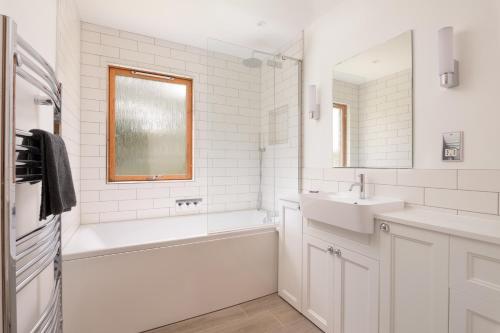 a white bathroom with a tub and a sink at Ballater Bungalow - 4 bed - Beautiful Garden in Ballater
