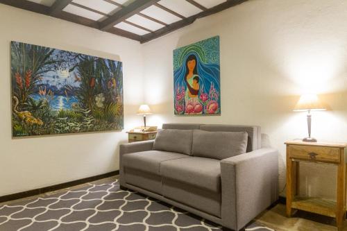 a living room with a couch and paintings on the wall at Don Pascual in Rio de Janeiro