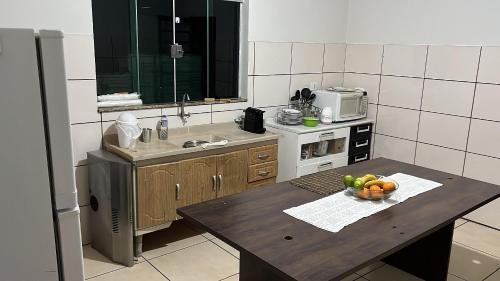 una cocina con una mesa con un bol de fruta. en Hostel Jotaaa F, en Ourinhos