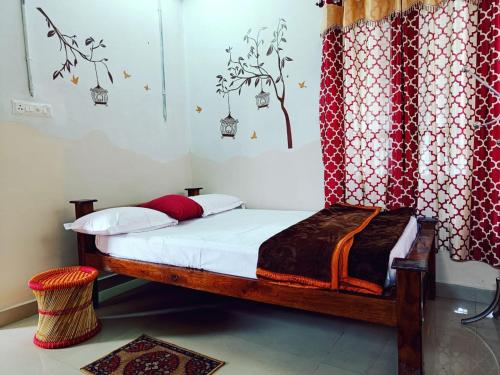 Schlafzimmer mit einem Bett mit einem roten und weißen Vorhang in der Unterkunft Tranquil Meadows Hues in Kattappana
