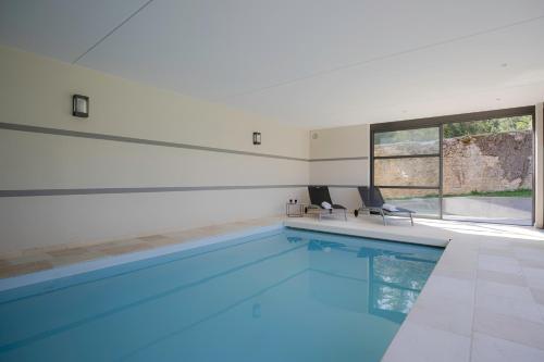 una piscina con 2 sillas en una casa en Domaine La Buissonnière 