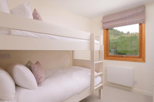 een slaapkamer met 2 stapelbedden en een raam bij Ballater Bungalow - 4 bed - Beautiful Garden in Ballater