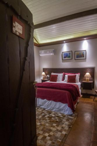 a bedroom with a large bed with red and white pillows at Don Pascual in Rio de Janeiro