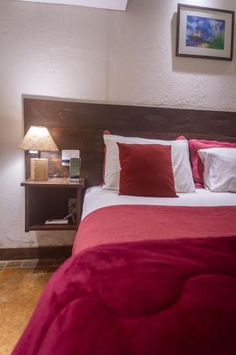 a bedroom with a large bed with a red blanket at Don Pascual in Rio de Janeiro