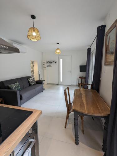 un salon avec une table et un canapé dans l'établissement L'atelier: charmante annexe indépendante, à Mâcon