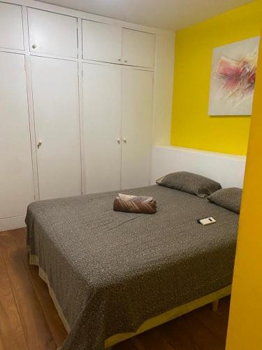 - une chambre avec 2 lits et un mur jaune dans l'établissement Apartamento Avenida Atlântica, à Rio de Janeiro
