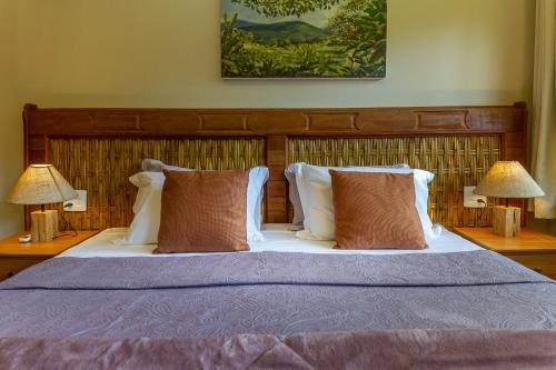 a bedroom with a bed with pillows and two lamps at Don Pascual in Rio de Janeiro