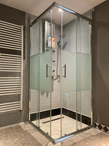 a shower stall with glass doors in a bathroom at Apartment im BOHO Stil nähe Salzburg in Freilassing