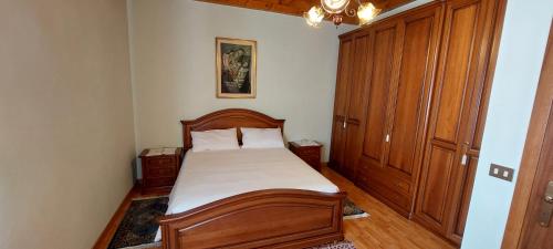 1 dormitorio con cama de madera y armario de madera en Casa Rosa, en Teolo