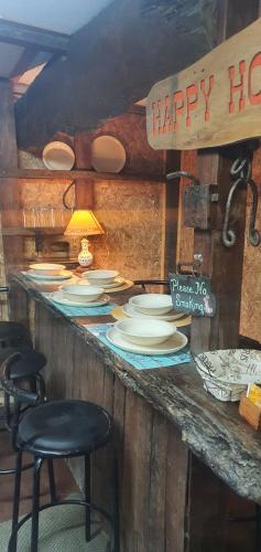 a counter with white plates and stools in a restaurant at REFUGIO CAMPESTRE A 7 MIN DE OSORNO in Osorno