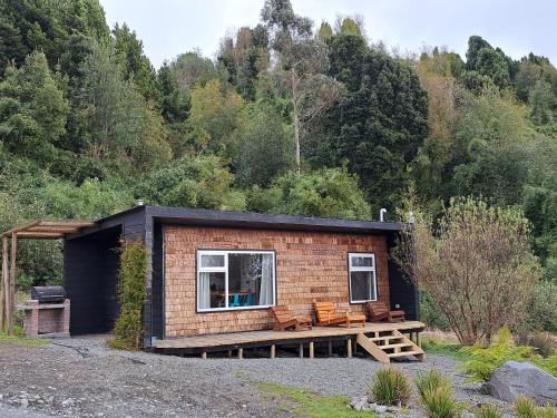 a tiny house with a porch and a deck at Casa Pumahue in La Ensenada