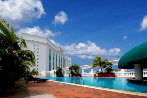 a hotel with a swimming pool in front of a building at Berjaya Waterfront Hotel, Johor Bahru in Johor Bahru