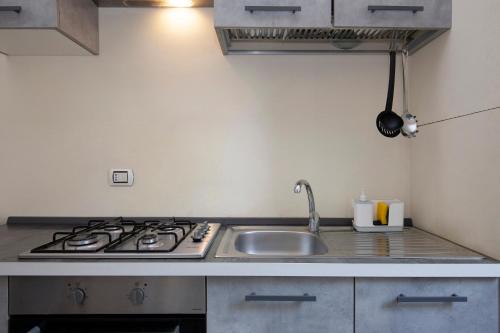 uma cozinha com um lavatório e um fogão forno superior em Casa Del Melograno em Veneza