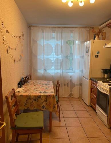 uma cozinha com uma mesa e um frigorífico em Makij apartment for night 5 em Narva