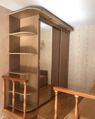 uma estante de madeira com um banco de madeira num quarto em Makij apartment for night 5 em Narva