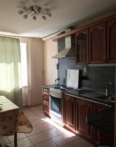 uma cozinha com armários de madeira e um forno com placa de fogão em Makij apartment for night 5 em Narva