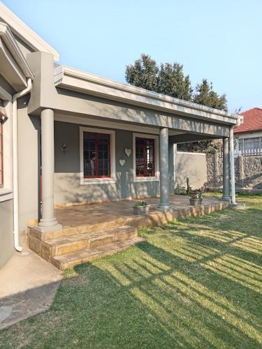 a house with a porch and a patio at Fancy Pansy 4: Secure Modern 2 bed family home in Germiston