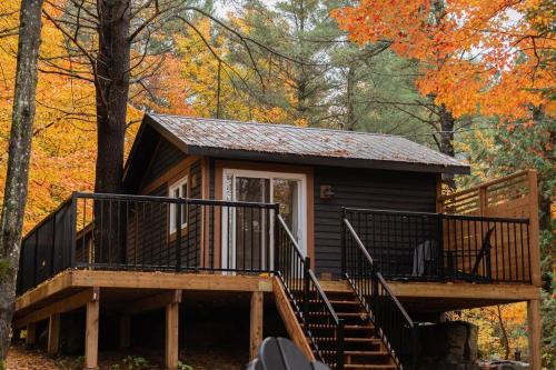 a small cabin in the woods with a staircase at The Doma Lodge - Cozy Muskoka Cabin in the Woods in Huntsville