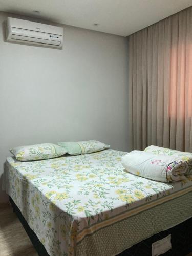 a bedroom with a bed with a floral bedspread at Casa completa e confortável in Leopoldina