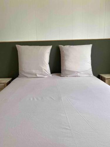 un grand lit blanc avec deux oreillers dessus dans l'établissement Grand chalet d’été avec piscine, à Bonifacio