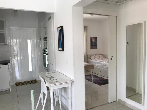 une cuisine blanche avec une table et une chambre dans l'établissement Casa Alta - villa med privat svømmebasseng, à Ciudad Quesada