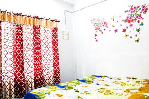 a bedroom with a bed with flowers on the wall at Tranquil Meadows Hues in Kattappana