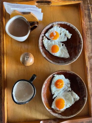 two bowls of eggs on a wooden tray at El Pozzo Hotel Campestre in Villa de Leyva
