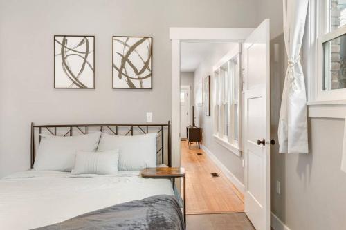 Dormitorio blanco con cama y pasillo en Modern condo in the heart of uptown Butte - Unit A en Butte