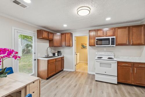 a kitchen with wooden cabinets and a white stove top oven at Elm Two Bedroom House in Historic Loveland in Loveland