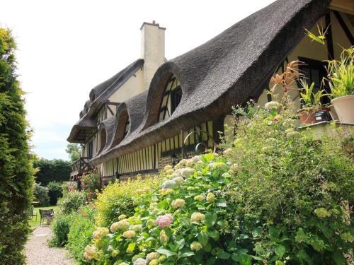 a house with a thatched roof and a bunch of flowers at Les Hauts d'Etretat in Bordeaux-Saint-Clair