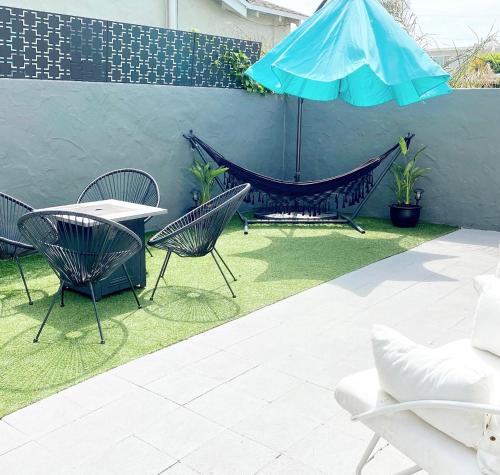 a patio with chairs and a table and an umbrella at Crown Point Home w/ Cowboy Pool 2 Blocks to Bay in San Diego